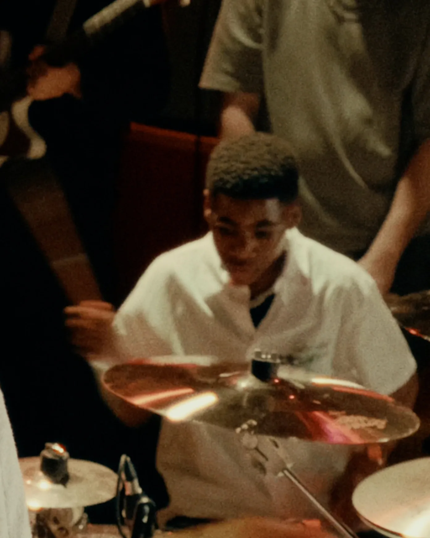 Boy in white shirt playing the drums